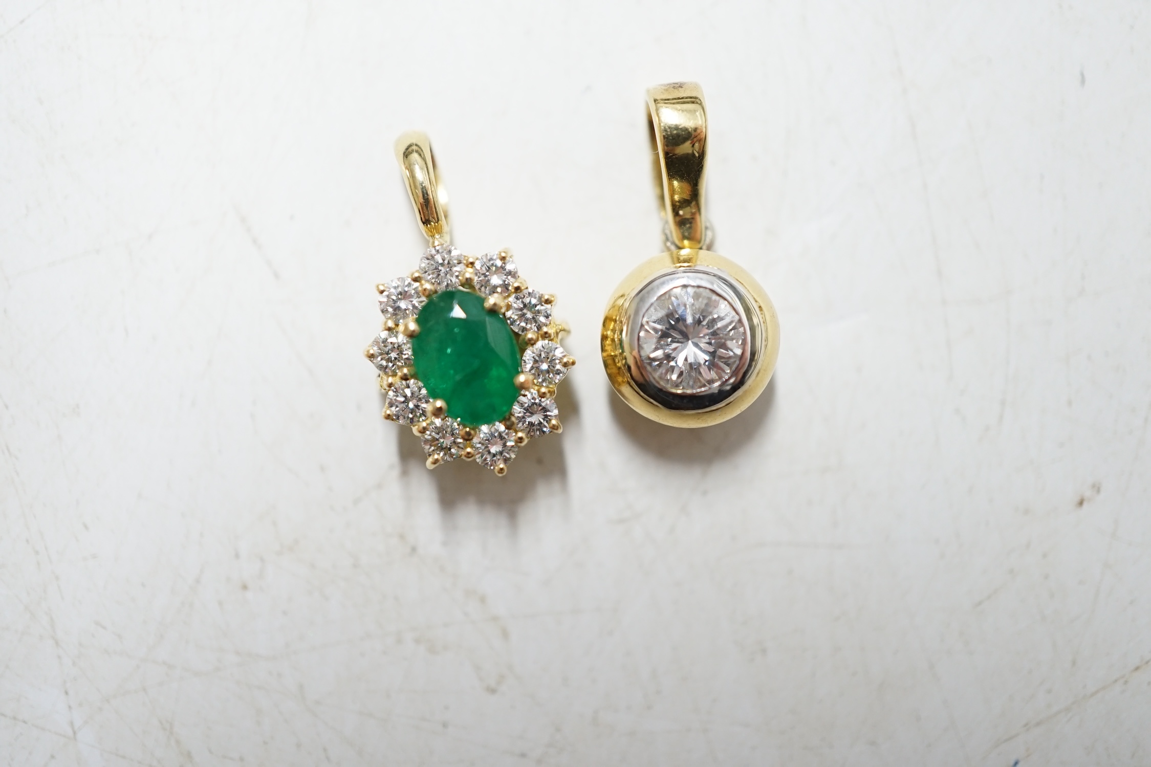 A modern 18ct gold and solitaire diamond set pendant and a similar unmarked yellow metal, emerald and diamond set oval pendant, gross weight 4,5 grams. Condition - fair to good